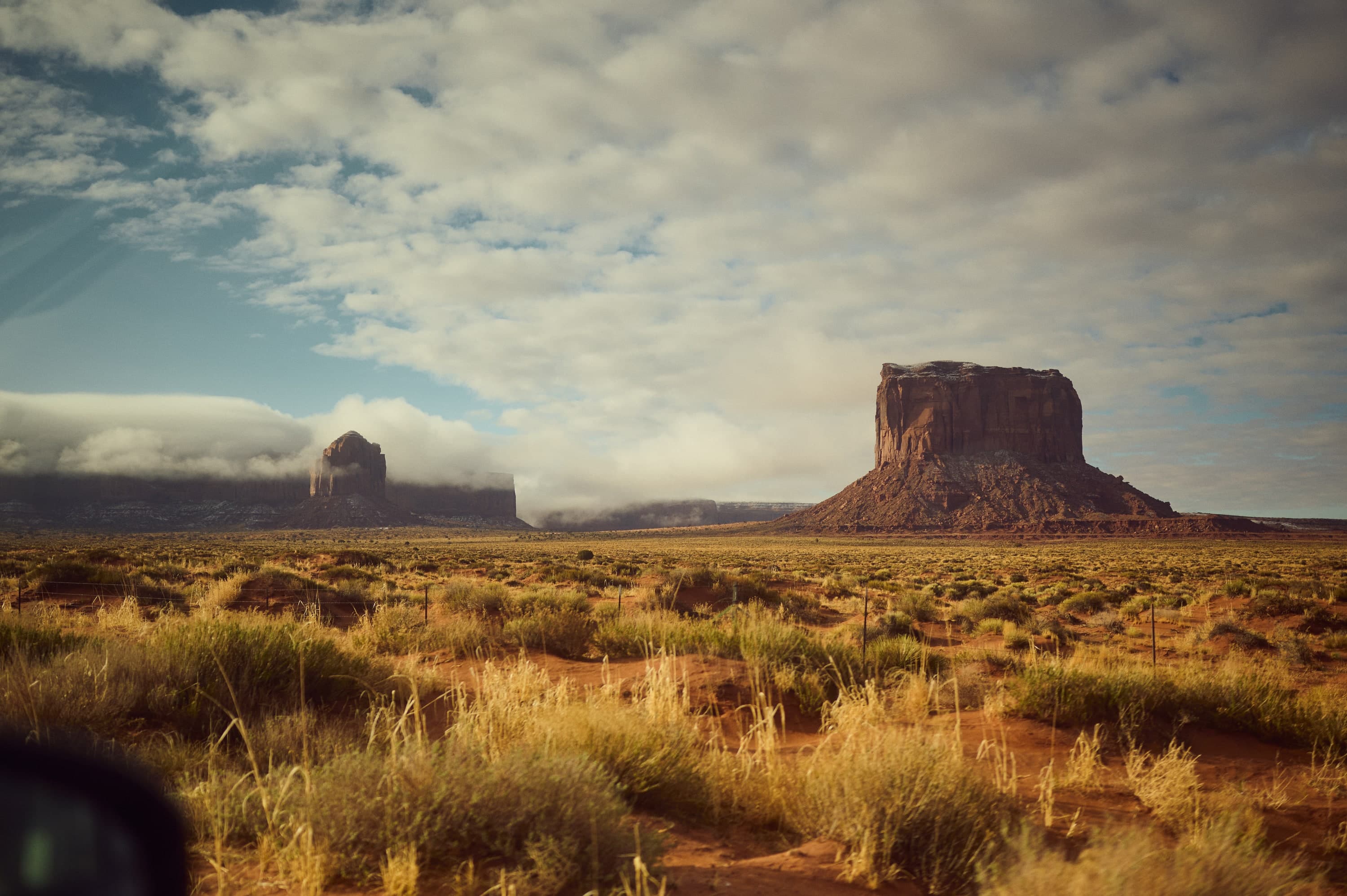 Tafelberge des Monument Valley über trockener Steppe unter Wolkendecke