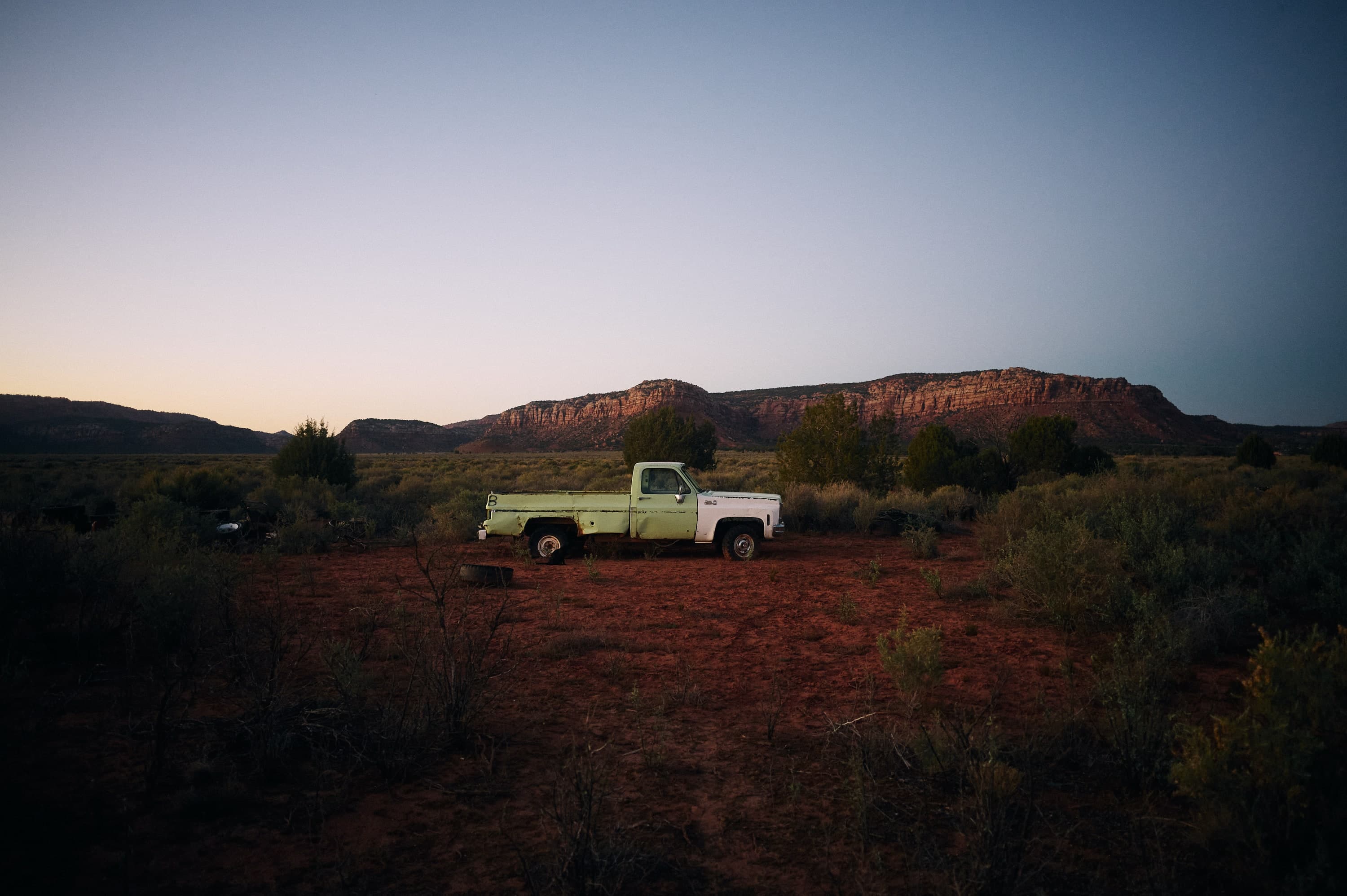 Alter Pickup-Truck in der Abenddämmerung vor roten Felsen