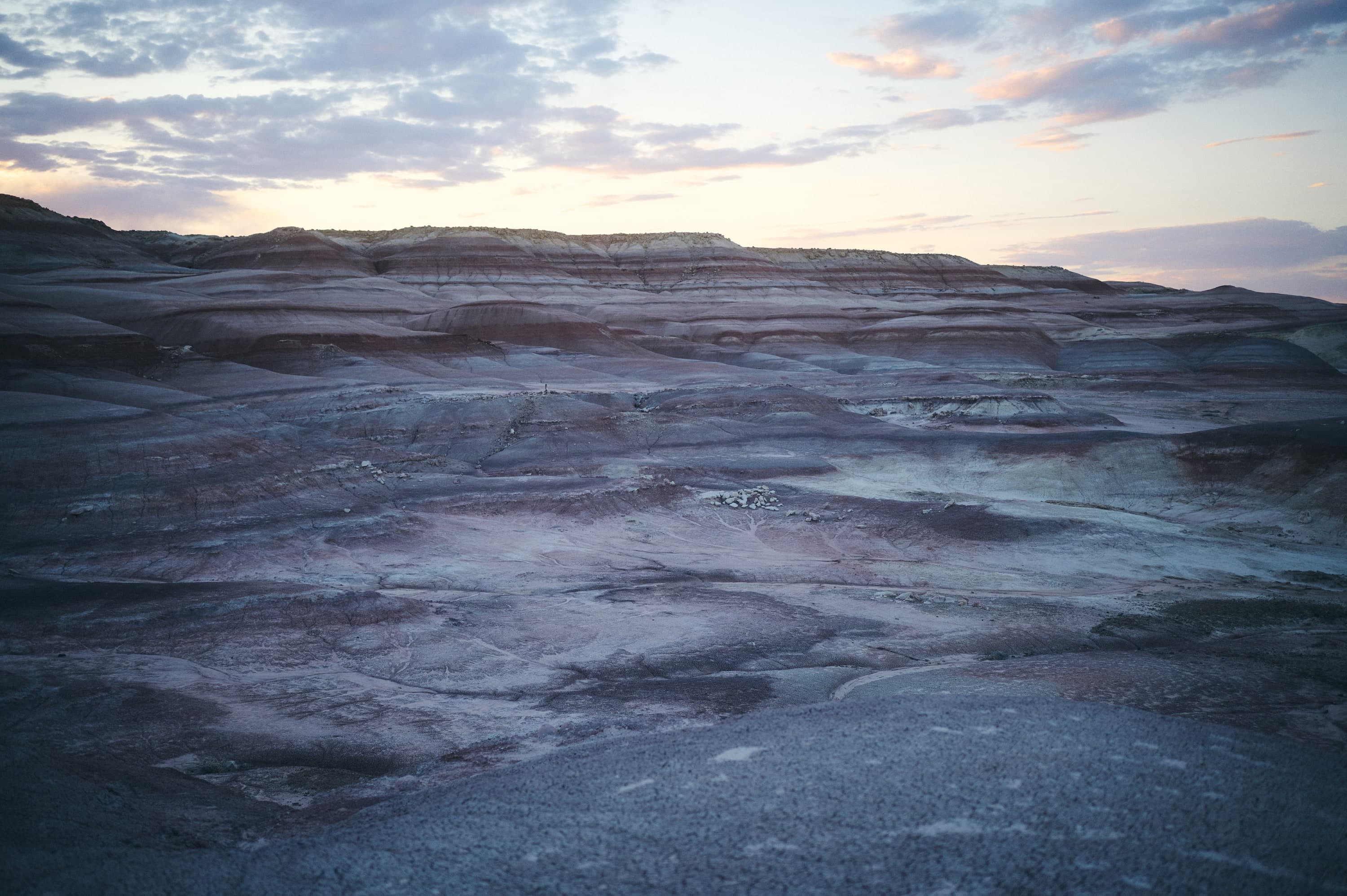 Violett und grau gebänderte Badlands der Bentonite Hills im Abendlicht